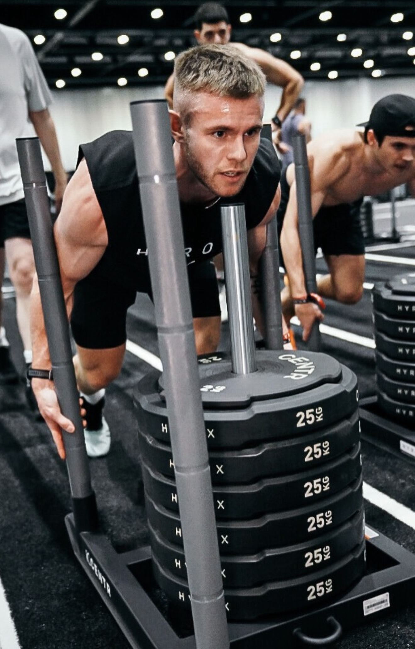 Dom Sharpe driving a weighted sled during a HYROX race